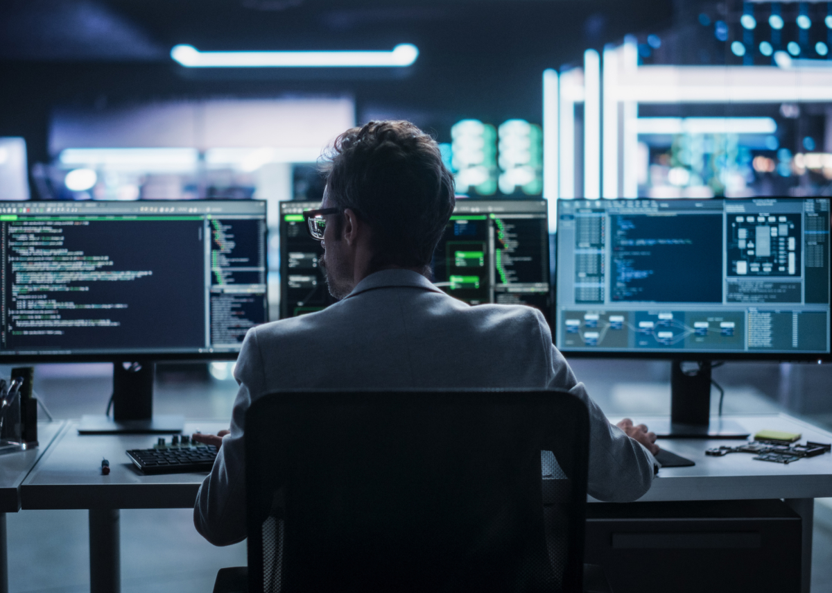 Man sitting in front of multiple monitors