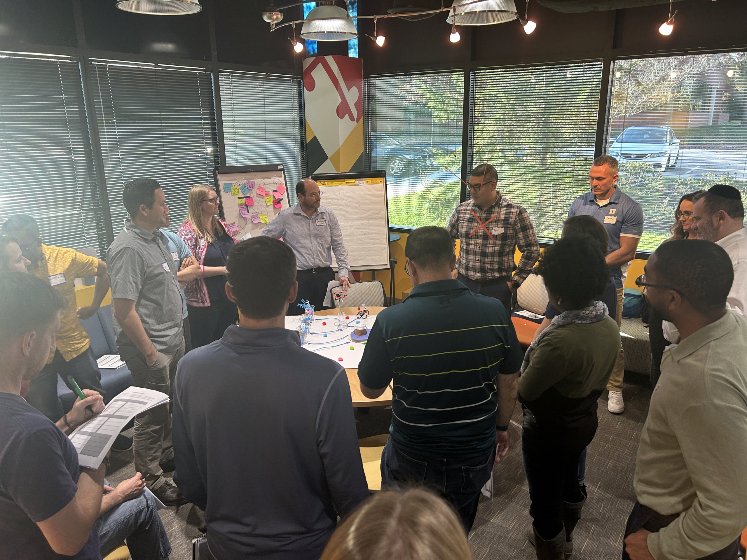 Team members standing around a table together