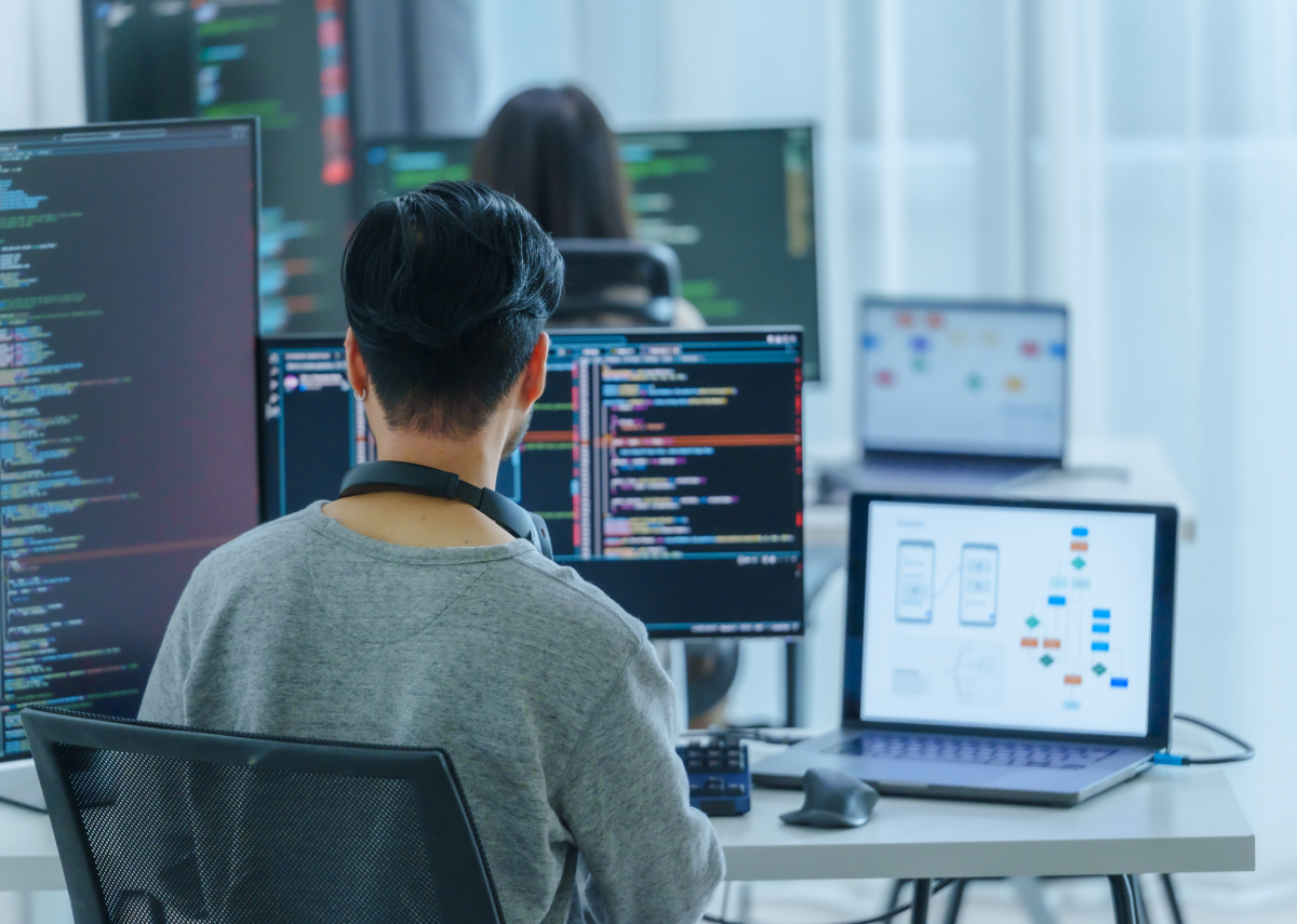 Person working with multiple computers